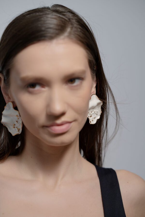 model Cristina Visterneanu wearing a pair of handcrafted jewelry adorned with gold details made by Diana Cojocaru