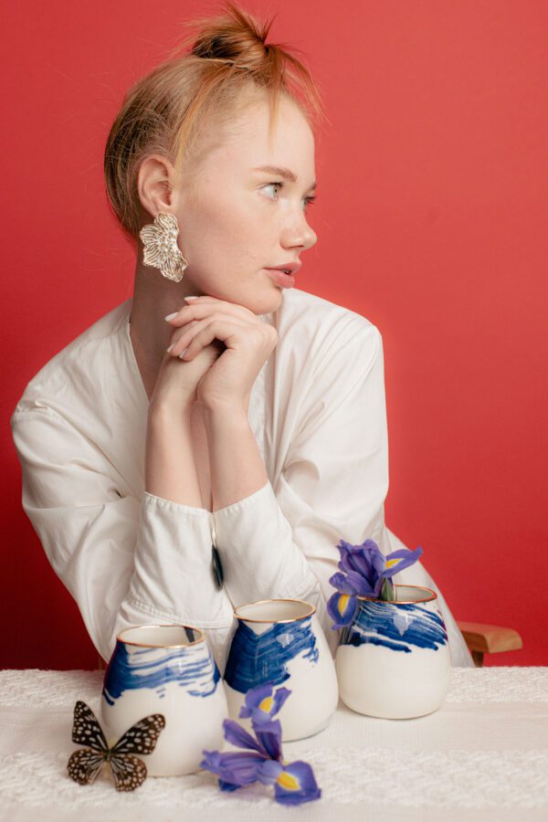 model wearing white flower earrings, handmade and meticulously detailed with 24k gold
